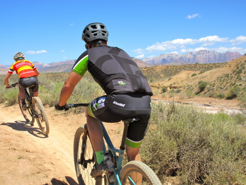 Riders on course with the towers of Zion National Park in the distance